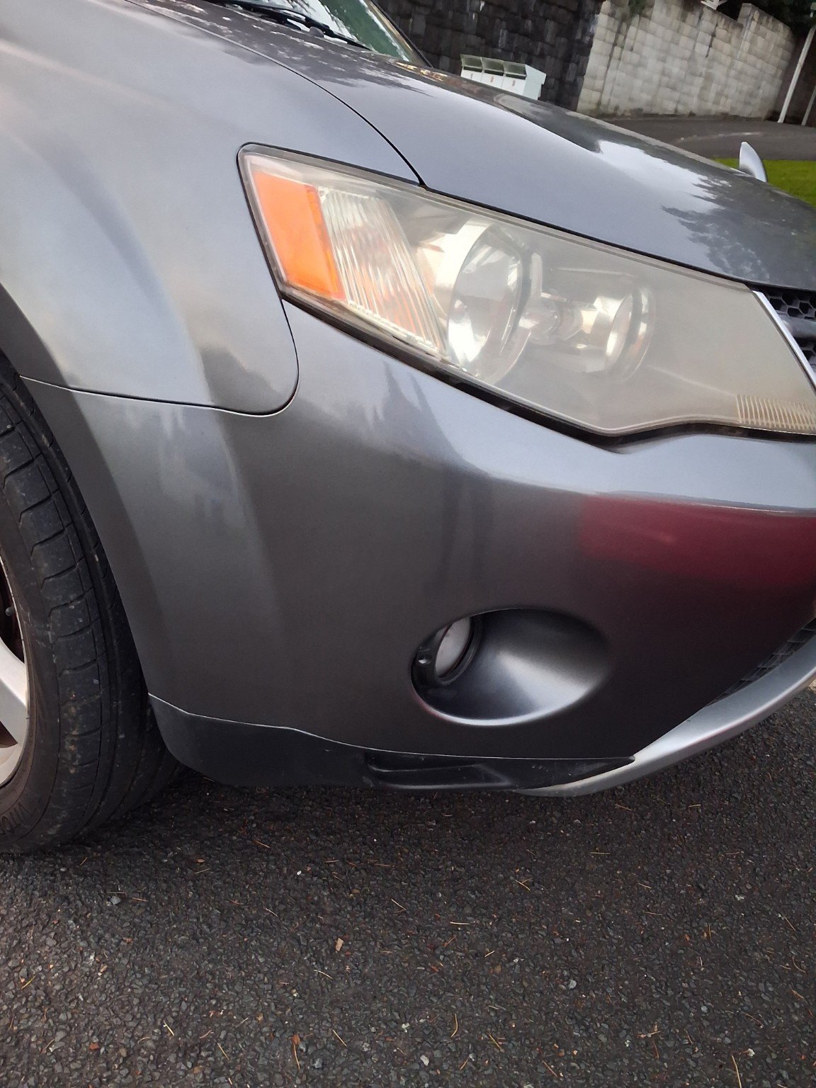 Grey car front bumper and panel area after bodywork repair