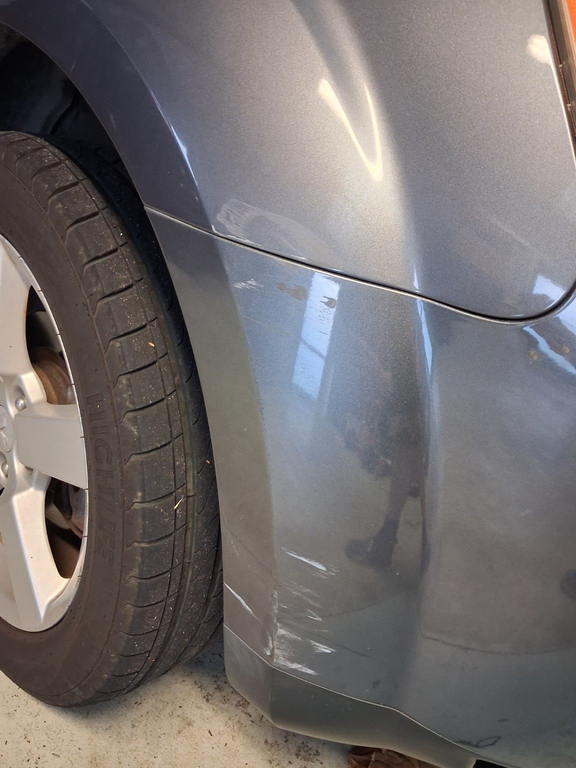 Grey car side panel with scratches and paint damage